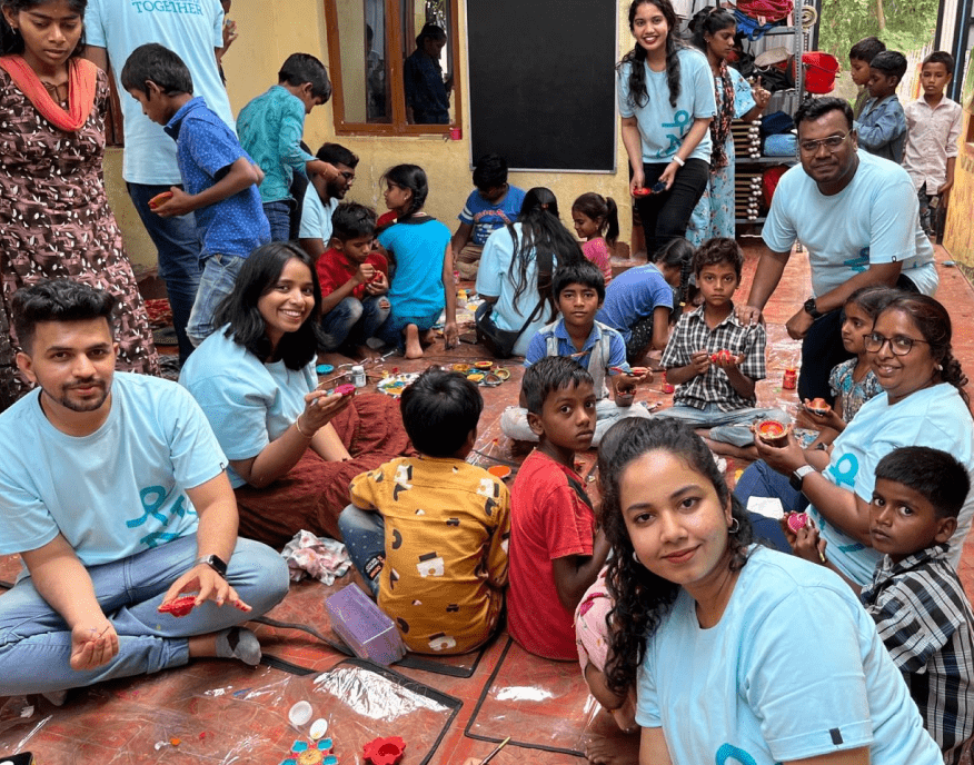 Image of Northern Trust Employees sitting with childrenand  volunteering at the Adaya Educational and Charitable Trust