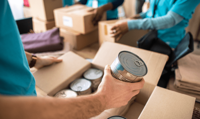 Image of a person putting a tin can into a box